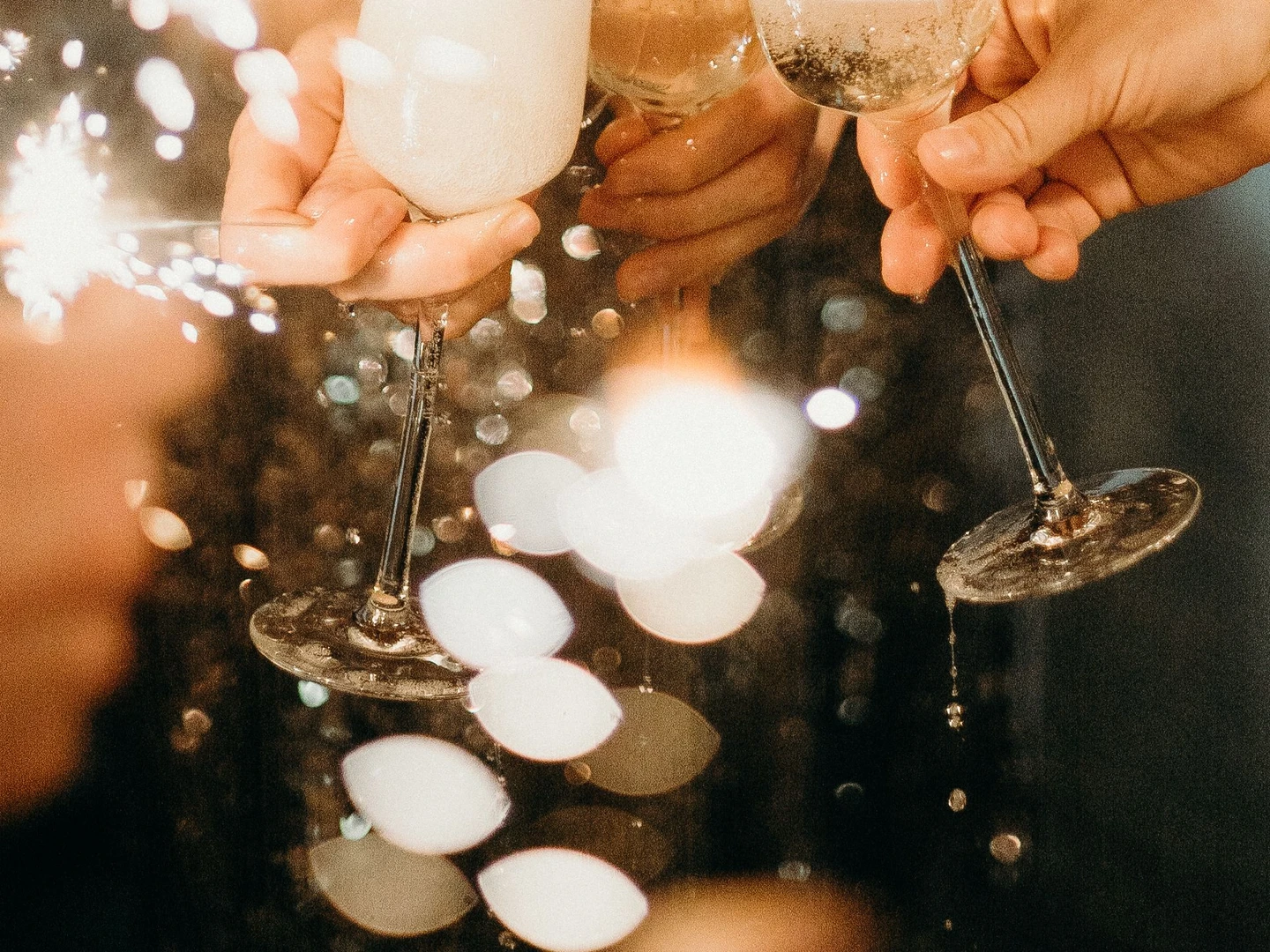 Copas alzadas en un brindis con luces de bengala