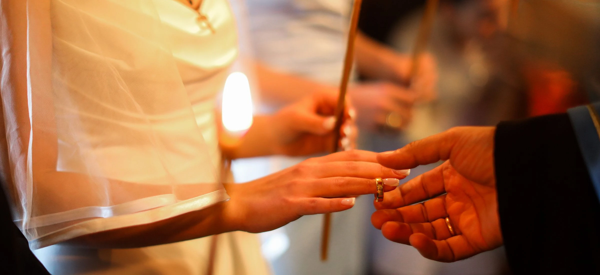 Manos intercambiando los anillos a la luz de las velas