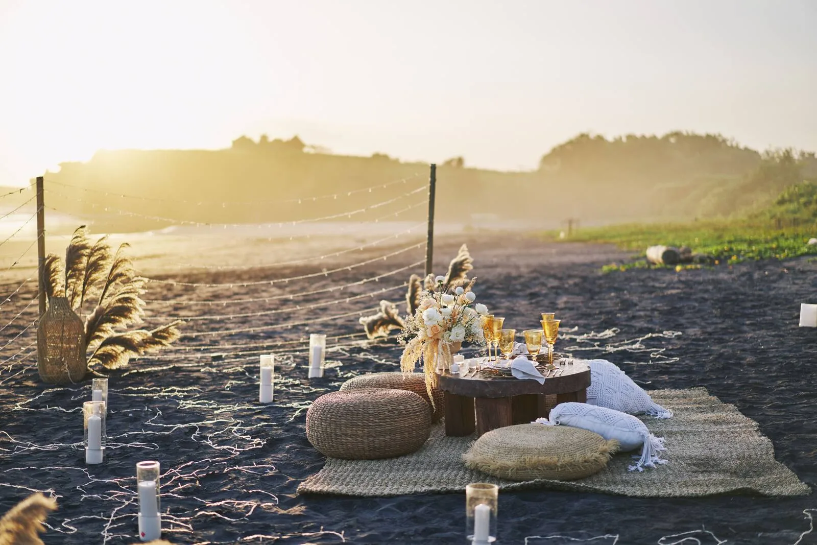 Mesa boho montada en la playa al atardecer