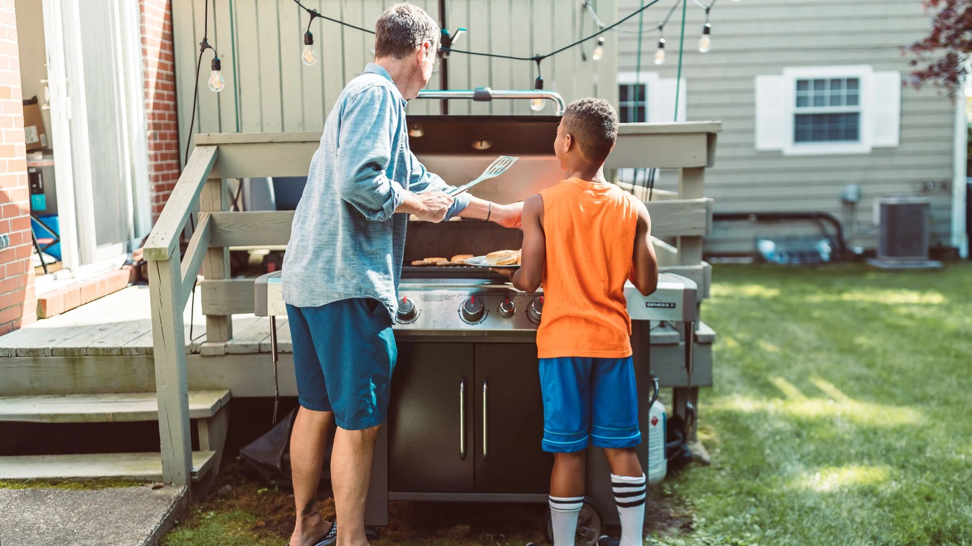 Pap&aacute; e hijo frente al asador